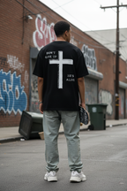 Mann trägt schwarzes Don't Give Up Oversized T-Shirt mit Backprint Kreuz He's Alive